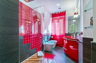 a red bathroom with a toilet and a sink at Trastevere, raffinato e silenzioso angolo in Rome