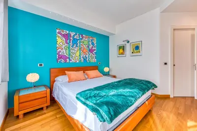 a bedroom with a bed with a blue wall at Trastevere, raffinato e silenzioso angolo in Rome