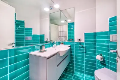 a blue tiled bathroom with a sink and a mirror at Trastevere, raffinato e silenzioso angolo in Rome