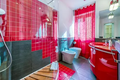 a red bathroom with a red sink and a toilet at Trastevere, raffinato e silenzioso angolo in Rome