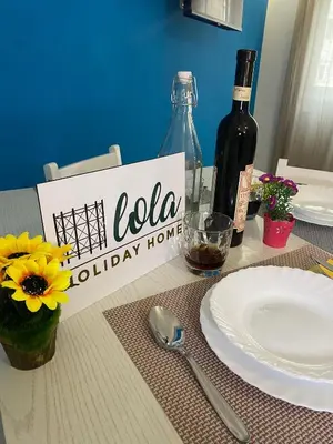 a table with a bottle of wine and a plate at Lola Holiday Home, Roma Ostiense in Rome
