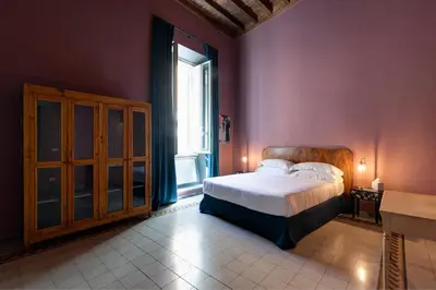 a bedroom with a bed and a large window at Appartamento Tor Millina 4 Piazza Navona in Rome