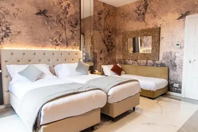 two beds in a bedroom with a wall mural at Adelaide Suite Dreams in Rome