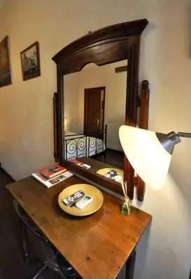 a wooden table with a lamp and a mirror at Le 3 Elle Vaticano San Pietro in Rome