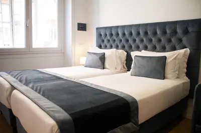 a bedroom with two beds with a large headboard at Michelangelo Vatican Guest House in Rome