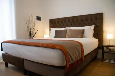 a bedroom with a large bed with a large headboard at Michelangelo Vatican Guest House in Rome
