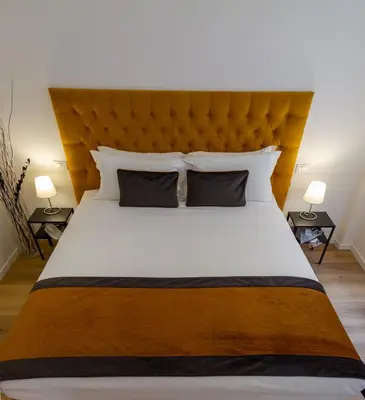 a bedroom with a large bed with a large headboard at Michelangelo Vatican Guest House in Rome