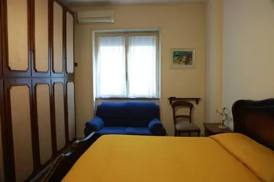 a bedroom with a bed and a blue chair and a window at San Peter’s Heaven’s Door in Rome