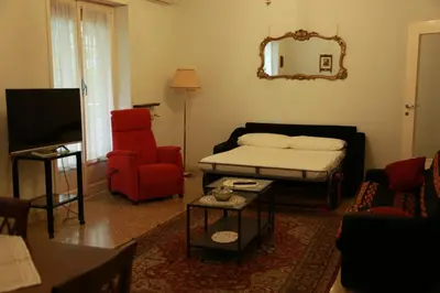 a living room with a bed and a red chair at San Peter’s Heaven’s Door in Rome