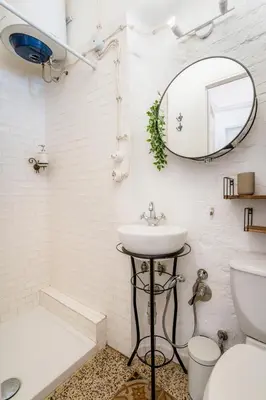 a white bathroom with a sink and a mirror at Casetta Giolitti, Cozy Apt in the Heart of Rome in Rome