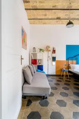a living room with a couch and a bed at Casetta Giolitti, Cozy Apt in the Heart of Rome in Rome