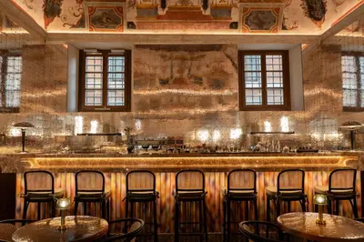 a bar with chairs and tables in a room at Palazzo Talìa - Small Luxury Hotels of the World in Rome