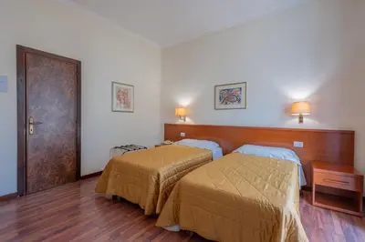 a bedroom with two beds and a wooden headboard at Hotel Monte Verde in Rome