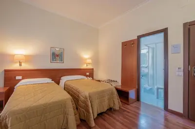 a hotel room with two beds and a glass door at Hotel Monte Verde in Rome