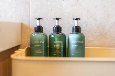 three green glass bottles sitting on a shelf at BigFamilyRome-Vatican&Aurelio in Rome