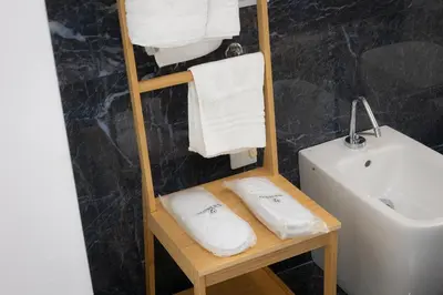 a bathroom with a sink and a towel rack with towels at Colosseo View Atmosphere by Rental in Rome in Rome