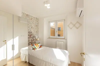 a white bedroom with a bed and a window at Colosseo View Atmosphere by Rental in Rome in Rome