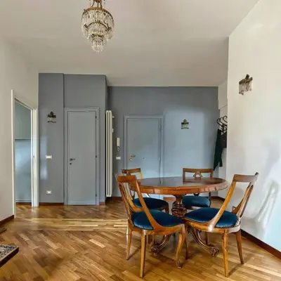 a dining room with a table and chairs and a chandelier at Splendido appartamento in Rome