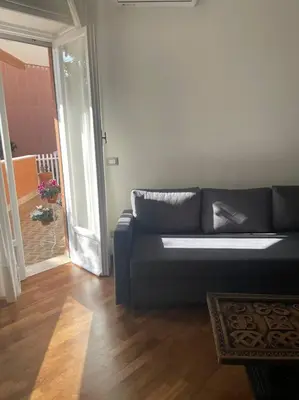 a living room with a black couch and a wooden floor at Splendido appartamento in Rome