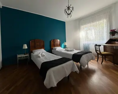 a blue bedroom with two beds and a piano at Splendido appartamento in Rome