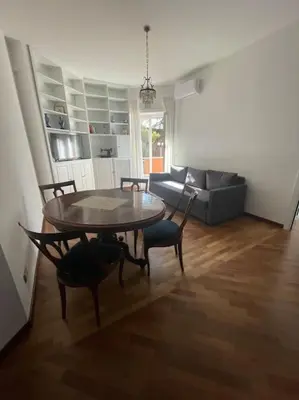 a living room with a table and chairs and a couch at Splendido appartamento in Rome