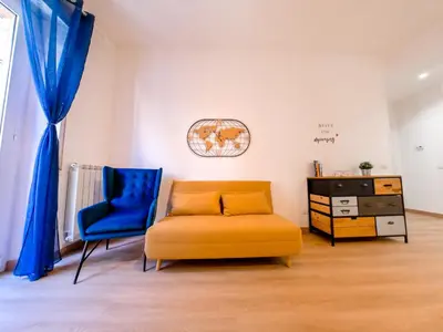 a living room with a yellow couch and a blue chair at Chic Modern 2-Bedroom near Metro in Rome