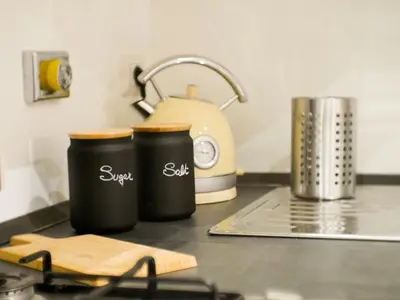two black containers on a kitchen counter with a tea kettle at Chic Modern 2-Bedroom near Metro in Rome