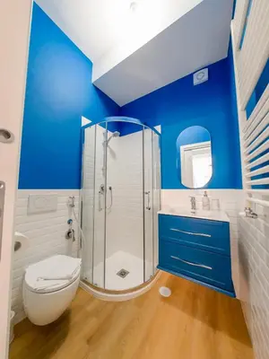 a blue bathroom with a toilet and a shower at Chic Modern 2-Bedroom near Metro in Rome