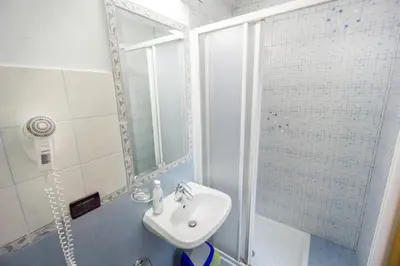 a white bathroom with a sink and a shower at Funny Palace Hostel in Rome