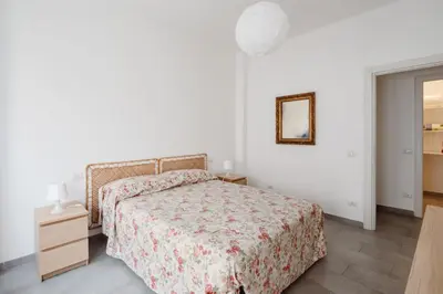 a white bedroom with a bed and a mirror at Caffarella Park View Rome in Rome