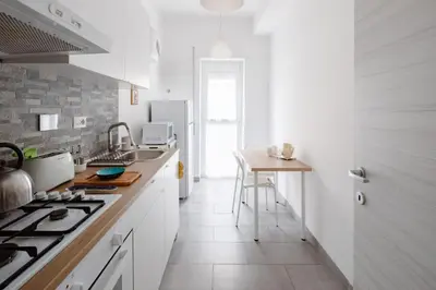 a kitchen with white counters and a stove top oven at Caffarella Park View Rome in Rome