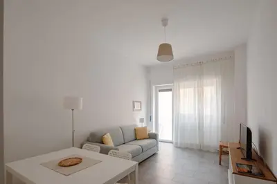 a white living room with a couch and a tv at Caffarella Park View Rome in Rome