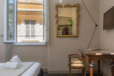 a bedroom with a mirror and a desk and a window at App Condotti Luxury Apartment In Rome in Rome