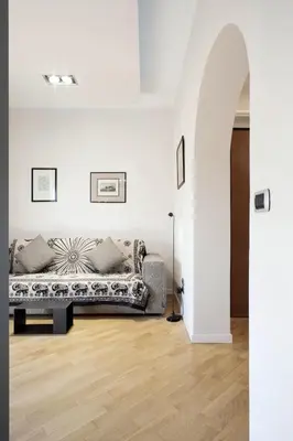 a living room with a couch in a white wall at The Attico_Prati in Rome