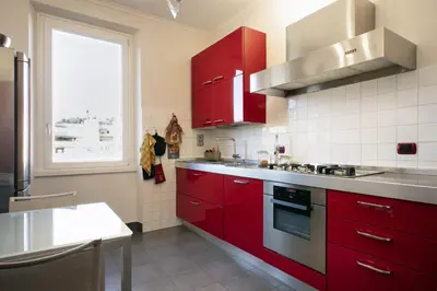 a kitchen with red cabinets and a window at The Attico_Prati in Rome