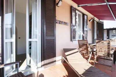 a balcony with chairs and a table and windows at The Attico_Prati in Rome