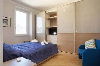 a bedroom with a blue bed and a tv at The Attico_Prati in Rome