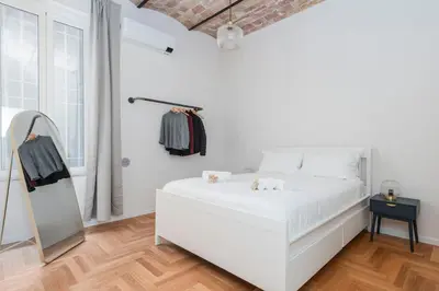 a white bedroom with a white bed and a mirror at Monti Zen Boutique Apartment-ZEN25 in Rome