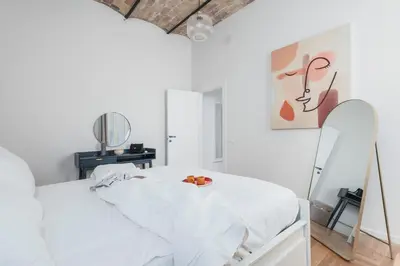a white bedroom with a white bed and a mirror at Monti Zen Boutique Apartment-ZEN25 in Rome