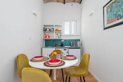 a kitchen with a white table and yellow chairs at Monti Zen Boutique Apartment-ZEN25 in Rome