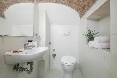 a white bathroom with a sink and a toilet at Monti Zen Boutique Apartment-ZEN25 in Rome
