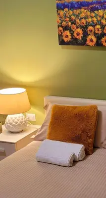 a bed with a pillow and a lamp on a table at Blessed Way in Rome