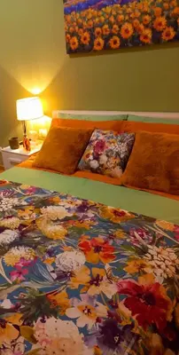a bedroom with a bed with a floral comforter at Blessed Way in Rome