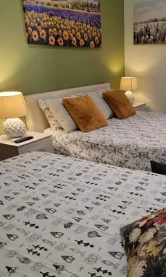 a bedroom with two beds and two tables with lamps at Blessed Way in Rome