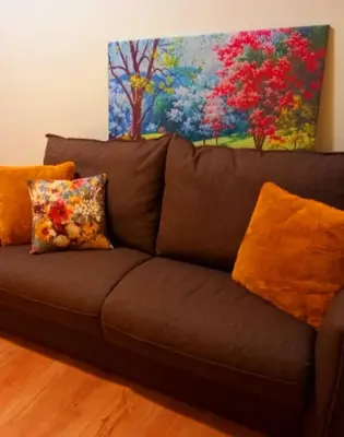 a brown couch with pillows and a painting on the wall at Blessed Way in Rome