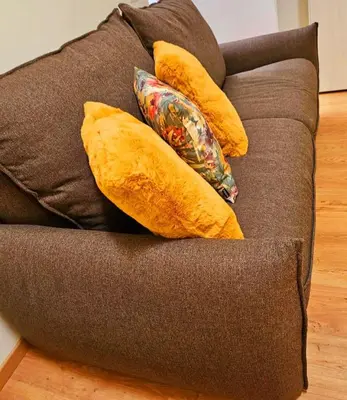 a couch with yellow pillows on top of it at Blessed Way in Rome