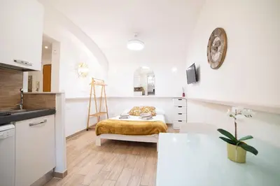 a white kitchen with a bed in a room at Locazione Turistica- Maxxi loft in Rome
