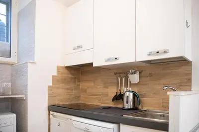 a kitchen with white cabinets and a sink at Locazione Turistica- Maxxi loft in Rome