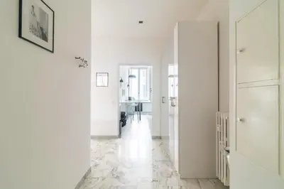 a white hallway with white walls and a floor with marble floors at Aureliana luxury apartment in Rome