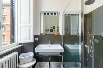 a bathroom with two sinks and a mirror at Aureliana luxury apartment in Rome